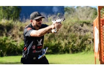 Competitive shooter Tucker Schmidt shooting a handgun.