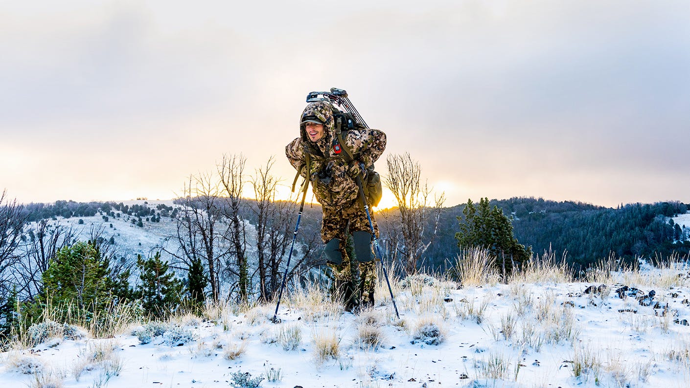 Elk hunter hiking in snow covered mountains.