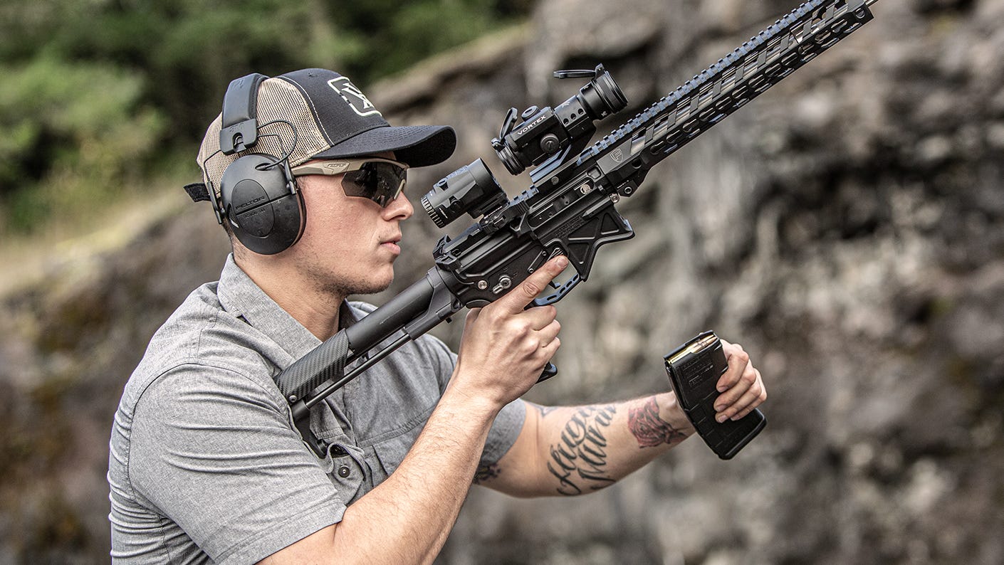 Shooter loading his weapon at an outdoor shooting range.