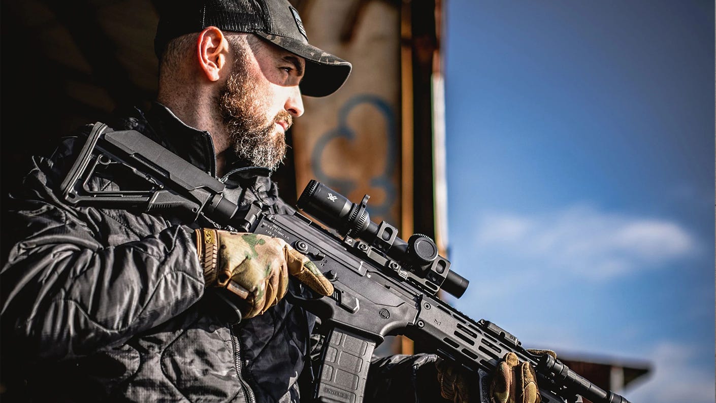 Man posing with a rifle and Vortex Strike Eagle 1-8x24 LPVO riflescope.