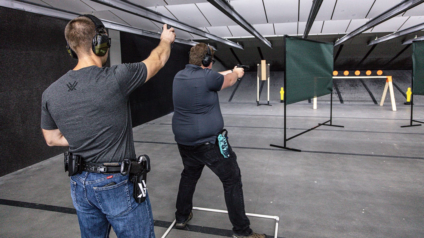 Action pistol training with instructor using a timer.